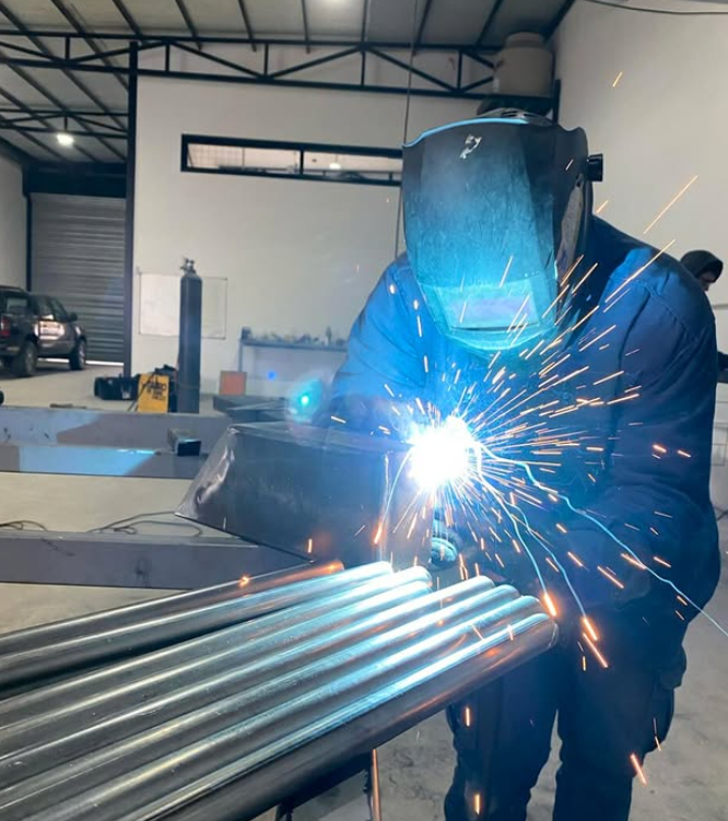 Soldador trabajando en estructura metálica